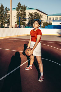 Portrait of young woman standing on road