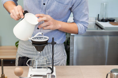 Midsection of man preparing food in kitchen at home