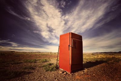 Refrigerator on field against sky