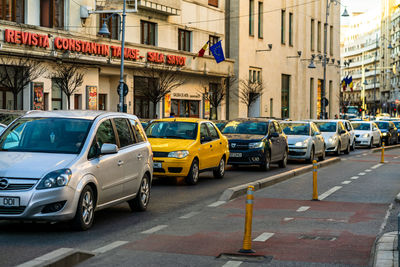 Cars on road by buildings in city