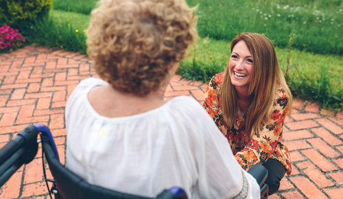 Rear view of friends smiling while standing outdoors