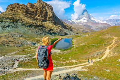 Rear view of woman looking at mountains against sky