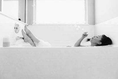 Young woman lying down in bathroom