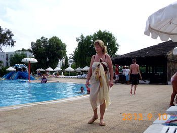 People on swimming pool against sky