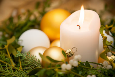 Close-up of illuminated candle and wreath