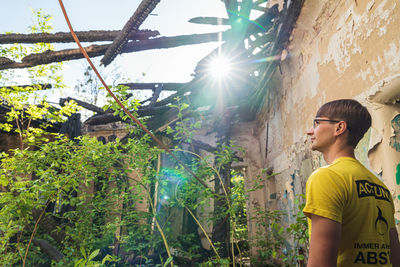 Low angel view of man standing by abandoned building