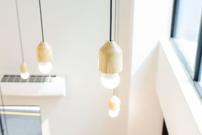 Close-up of light bulb hanging on table at home