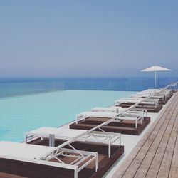 View of swimming pool by sea against clear sky