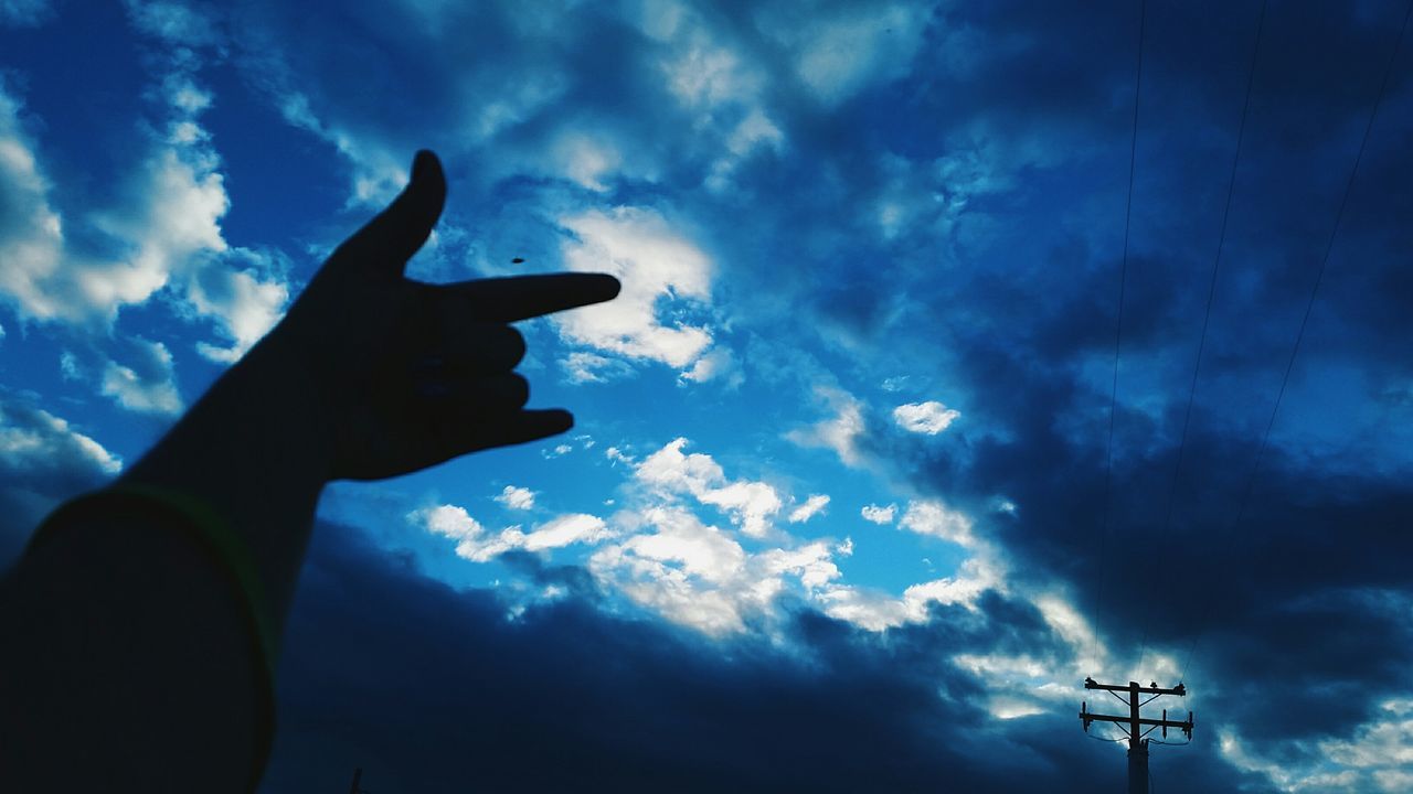 low angle view, sky, silhouette, part of, cloud - sky, person, human finger, cropped, cloud, cloudy, dusk, blue, holding, technology, outdoors, sunset, airplane