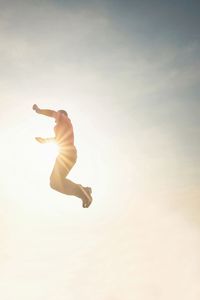 Jumping man in the sky. man jumping in the sunshine against blue sky.