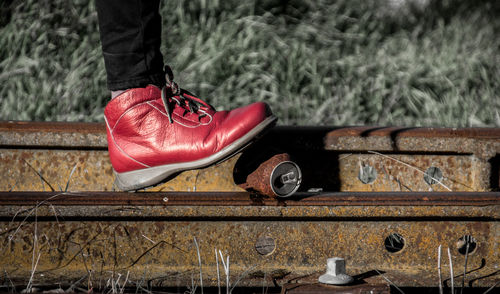 Low section of person crushing rusty drink can on railroad station