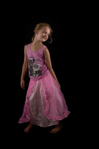 Young woman standing against black background