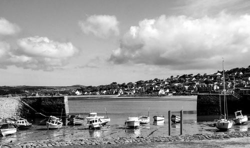 Boats moored on beach against sky