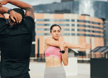 Portrait of young woman exercising in city