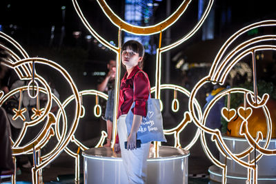 Full length of a boy holding umbrella at night