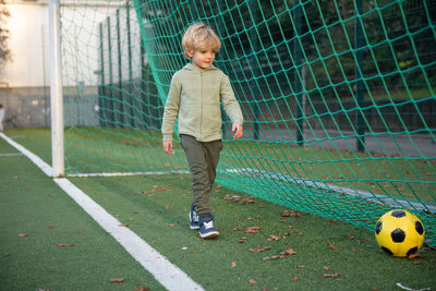 A little boy plays soccer on the soccer field