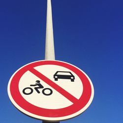 Low angle view of road sign against blue sky