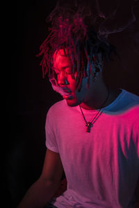 Portraits of beautiful african young man under blu and red lights