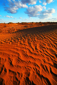 Scenic view of desert against cloudy sky