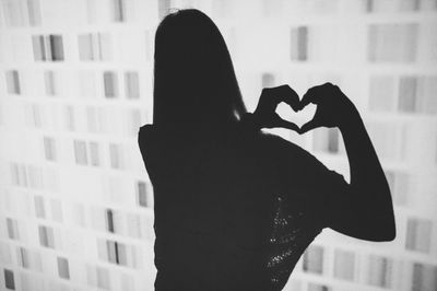 Silhouette of woman standing by building