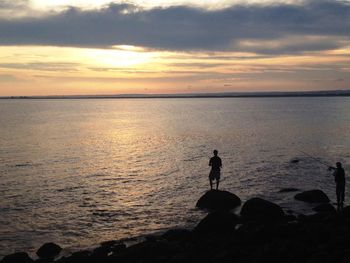 Silhouette of man in sea at sunset