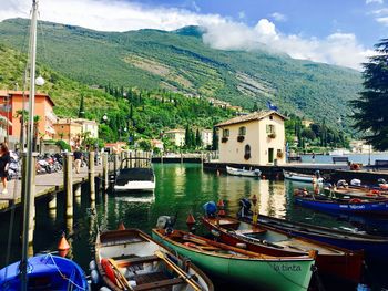 Boats moored in canal amidst buildings in city