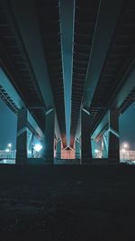 Low angle view of bridge in city at night