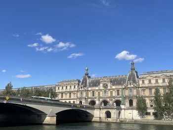 Arch bridge over river against buildings in city