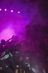 Group of people in illuminated nightclub at night