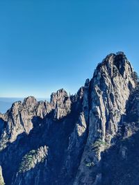 Scenic view of rocky mountains against clear blue sky