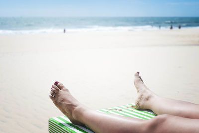 Low section of woman relaxing on beach