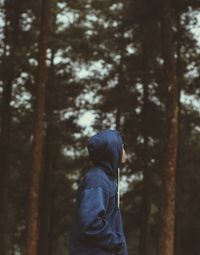 Side view of man standing at forest