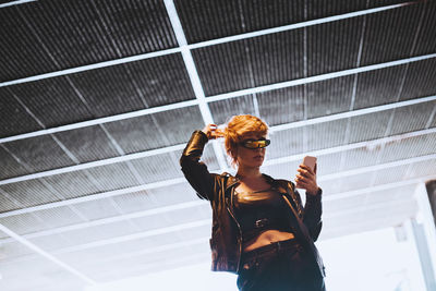 Woman using mobile phone at underpass