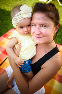 Portrait of woman with cute girl at back yard