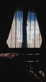 Man relaxing on bed seen through window