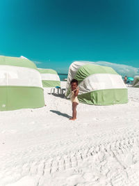 Man on beach against clear sky on sunny day