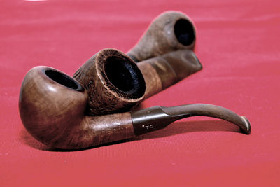 Close-up of wooden smoking pipes on red tablecloth