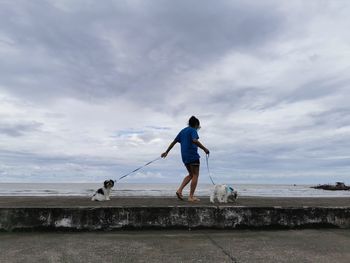 Man with dog against sky