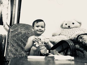 Portrait of cute boy sitting at toy at home