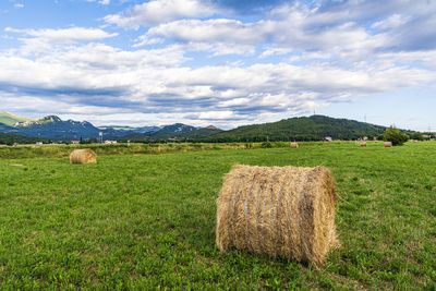 Hay bales on field against sky