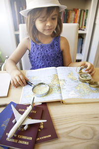 Portrait of a smiling young woman with book on table