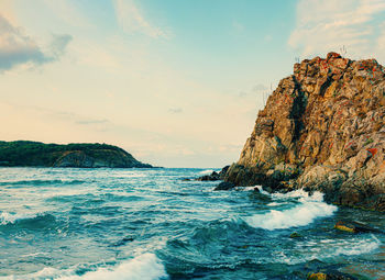 Rock formations in sea against sky