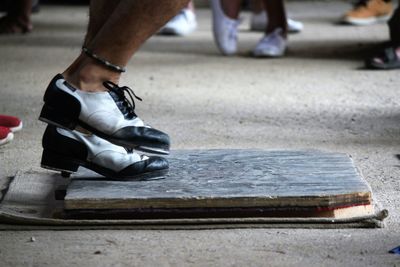 Low section of man tap dancing on wood