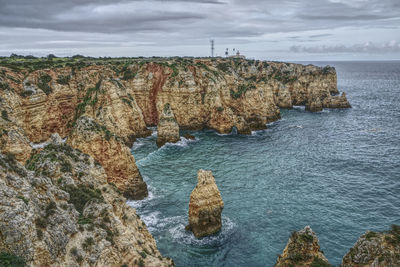 Scenic view of rocks in sea against sky