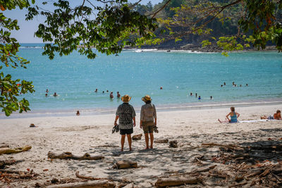 People at beach against sky