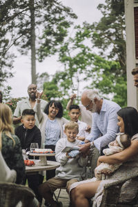 Grandfather giving gift to grandson while celebrating birthday