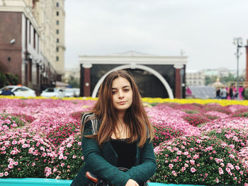 Portrait of beautiful woman with pink flower in background