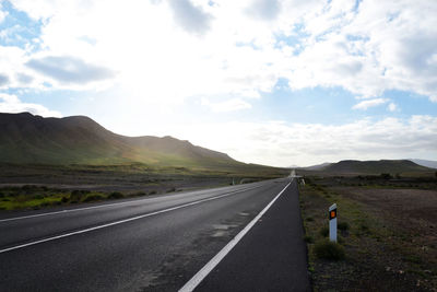 Empty road leading towards mountains