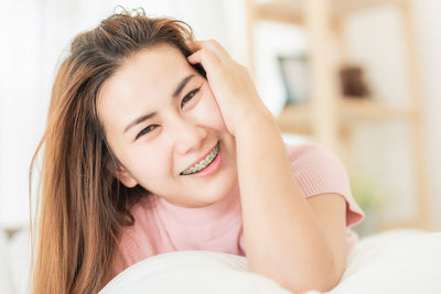 Portrait of happy woman relaxing on bed at home