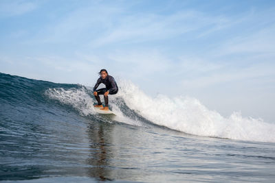 Man surfing on sea against sky